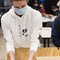 Student places a robot on the track